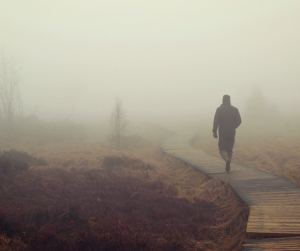 Person walking alone in a different direction from a crowd symbolizing independence and self-direction